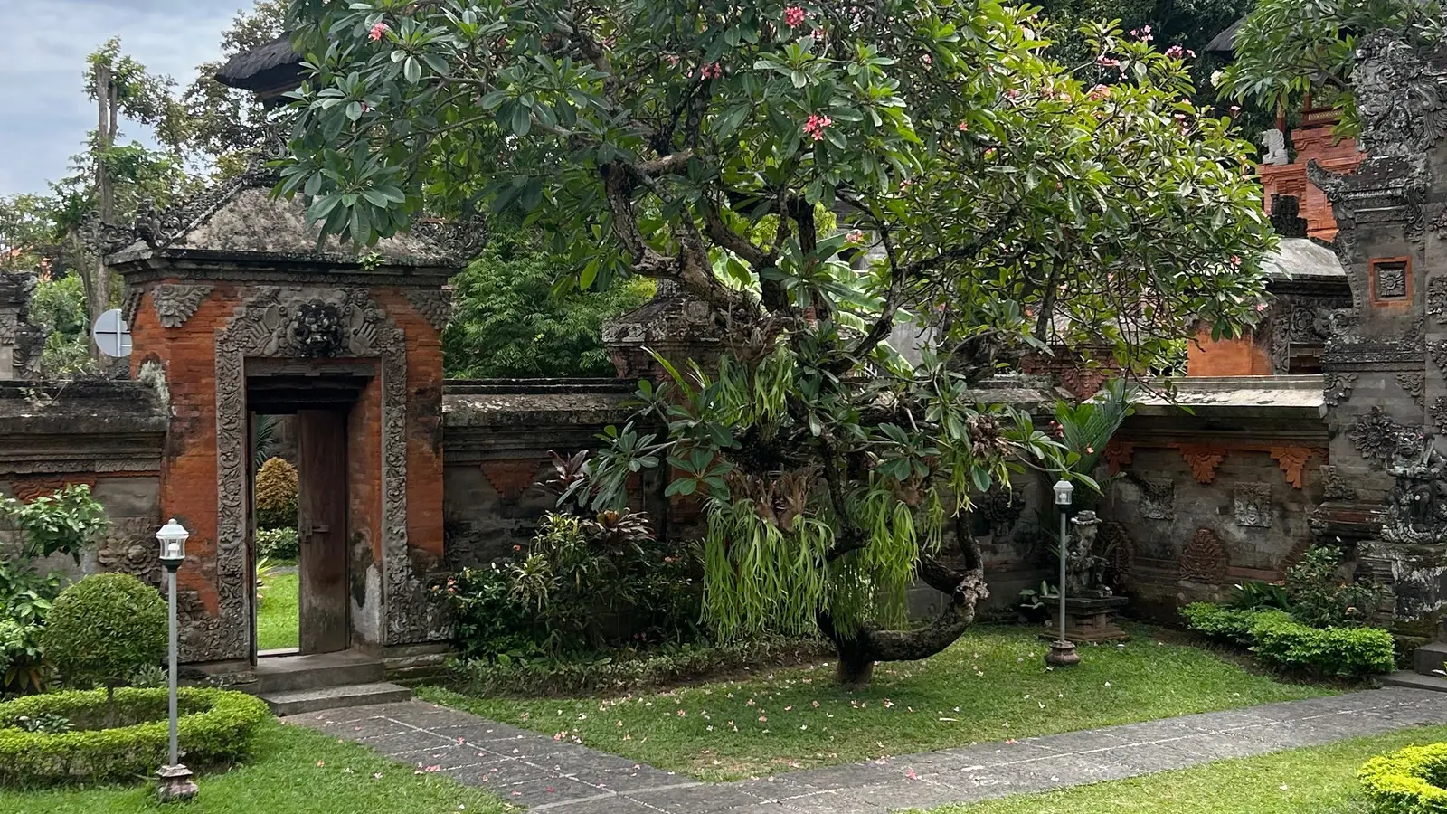 Green garden in front of traditional Balinese buildings