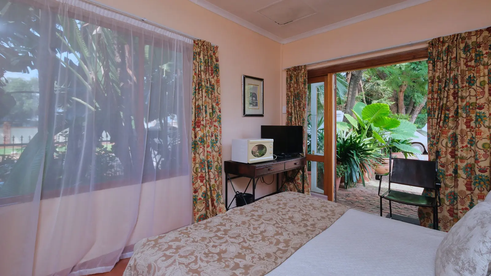 A bright bedroom with an open door to a garden